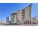 Modern condo building showcasing architectural details and multiple floors with balconies under clear blue skies at 290 W 12Th Ave # 205, Denver, CO 80204