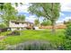 Expansive backyard with a wooden deck, a concrete patio, mature landscaping, and a privacy fence at 7503 Saulsbury St, Arvada, CO 80003