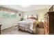 Comfortable bedroom with large window, floral drapes, carpeted floor and furnishings at 7503 Saulsbury St, Arvada, CO 80003