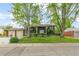 Charming brick home with a well-manicured lawn and mature trees, creating a welcoming curb appeal at 7503 Saulsbury St, Arvada, CO 80003