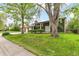 Attractive front yard with lush green lawn, mature trees, and brick facade in a desirable neighborhood at 7503 Saulsbury St, Arvada, CO 80003