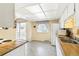Functional kitchen with white cabinets, butcher block countertops, and a convenient sliding door to the outside at 7503 Saulsbury St, Arvada, CO 80003