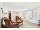 Bright living room features neutral walls, comfortable seating, and a large window with neighborhood views at 7503 Saulsbury St, Arvada, CO 80003