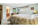 Comfortable bedroom featuring carpet floors, window, floral drapes, and ensuite bathroom at 7503 Saulsbury St, Arvada, CO 80003
