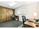 Office space features a wood paneled accent wall, carpet flooring and natural light at 7503 Saulsbury St, Arvada, CO 80003