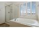 Bright bathroom features a soaking tub with shower and window at 1757 Baguette Dr, Castle Rock, CO 80108