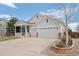 Two-story gray home with a three-car garage, front porch, and manicured landscaping in the front yard at 1757 Baguette Dr, Castle Rock, CO 80108