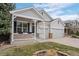 Close-up of a well-manicured gray home featuring a welcoming front porch and attached two-car garage at 1757 Baguette Dr, Castle Rock, CO 80108