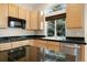 Kitchen featuring black countertops, stainless steel appliances and wood cabinets at 1757 Baguette Dr, Castle Rock, CO 80108