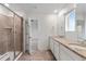 Bright bathroom with dual sinks, granite countertop, and walk-in shower at 9479 Rifle St, Commerce City, CO 80022