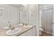 Well-lit bathroom featuring double sinks, a large mirror, and a separate toilet and shower area at 9479 Rifle St, Commerce City, CO 80022