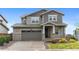 Charming two-story home with a gray exterior, two-car garage, and landscaped front yard at 9479 Rifle St, Commerce City, CO 80022