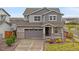 Charming two-story home with a two-car garage, covered porch, and well-maintained front yard at 9479 Rifle St, Commerce City, CO 80022
