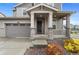 Inviting front porch with stone accents, neutral colors, and well-maintained landscaping at 9479 Rifle St, Commerce City, CO 80022