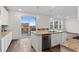 Modern kitchen with granite countertops, island seating, and sliding door access to outdoor deck at 9479 Rifle St, Commerce City, CO 80022
