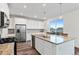Well-lit kitchen with stainless steel appliances, granite countertops, and a central island with sink at 9479 Rifle St, Commerce City, CO 80022