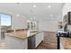 Well-lit kitchen area with an island and stainless steel appliances open to the living area at 9479 Rifle St, Commerce City, CO 80022