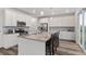 Bright kitchen featuring white cabinets, stainless steel appliances, and a large center island with bar seating at 9479 Rifle St, Commerce City, CO 80022