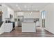 Spacious kitchen features white cabinets, stainless steel appliances, and a large island with pendant lighting at 9479 Rifle St, Commerce City, CO 80022