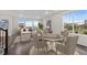 Bright living area with large windows and a dining table setup, showcasing an open-concept space at 9479 Rifle St, Commerce City, CO 80022