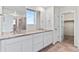 Main bathroom with dual sinks, granite countertop, and a separate shower at 9479 Rifle St, Commerce City, CO 80022