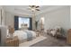 Relaxing main bedroom featuring a tray ceiling, large windows, and stylish decor at 9479 Rifle St, Commerce City, CO 80022