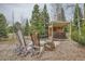 Backyard features a covered hot tub, ski Adirondack chairs and natural setting, perfect for relaxing and unwinding at 19375 Sherwood Trl, Monument, CO 80132