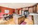 Open kitchen features a large island with a cooktop, granite countertops, and wood cabinets at 19375 Sherwood Trl, Monument, CO 80132