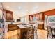 Well-lit open kitchen boasts a granite-topped island, breakfast bar, stainless appliances, and wood cabinets at 19375 Sherwood Trl, Monument, CO 80132