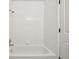 Bathroom featuring a tiled bathtub with shower and a white door at 925 Elm St, Denver, CO 80220