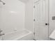 Bathroom featuring a tiled bathtub with shower and a white door at 925 Elm St, Denver, CO 80220