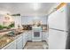 Bright kitchen showcasing light blue cabinets, granite countertops, white appliances, and wood-look flooring at 4460 S Pitkin St # 119, Aurora, CO 80015