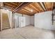 Unfinished basement featuring stairs, a white refrigerator, and wrapped walls at 10681 Cherrybrook Cir, Highlands Ranch, CO 80126