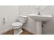 Modern half bathroom featuring a pedestal sink and toilet at 10681 Cherrybrook Cir, Highlands Ranch, CO 80126