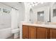 This bathroom features a shower, bathtub, dual sinks and updated wood cabinetry at 10681 Cherrybrook Cir, Highlands Ranch, CO 80126
