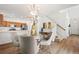 Elegant dining area with a chandelier, glass table, and a view of the modern kitchen and staircase at 10681 Cherrybrook Cir, Highlands Ranch, CO 80126