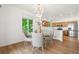 Charming dining area with a chandelier, glass table, and a view of the modern kitchen and backyard at 10681 Cherrybrook Cir, Highlands Ranch, CO 80126
