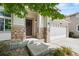 Inviting entryway with stone pillars, a decorative wreath on the brown front door, and a spacious two-car garage at 10681 Cherrybrook Cir, Highlands Ranch, CO 80126