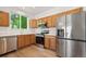 Well-lit kitchen with wood cabinets, stainless steel appliances, and views of the yard at 10681 Cherrybrook Cir, Highlands Ranch, CO 80126