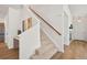 Elegant staircase with wooden railing, modern lighting, and neutral decor at 10681 Cherrybrook Cir, Highlands Ranch, CO 80126