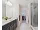 Bathroom with double sink vanity, a glass-enclosed shower, and a view into the closet at 17214 W 94Th Ave, Arvada, CO 80007