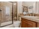 Bathroom features glass shower and vanity with a decorative mirror at 13360 W 83Rd Pl, Arvada, CO 80005