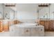 Bright bathroom featuring a large soaking tub, dual vanities, and neutral tile work at 13360 W 83Rd Pl, Arvada, CO 80005