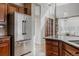Bright, open kitchen featuring custom wood cabinets, a stainless steel refrigerator, and a granite island at 13360 W 83Rd Pl, Arvada, CO 80005