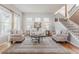Bright living room with light hardwood floors, a neutral color palette, and a cozy seating arrangement at 13360 W 83Rd Pl, Arvada, CO 80005