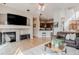 Spacious living room with a fireplace, hardwood floors, and an open view to the kitchen and dining area at 13360 W 83Rd Pl, Arvada, CO 80005