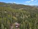 Secluded home surrounded by a dense forest with mountain views in the distance at 8905 Carol Ln, Conifer, CO 80433