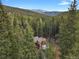 Breathtaking aerial view of a secluded log home nestled amidst a dense forest at 8905 Carol Ln, Conifer, CO 80433