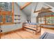 Bedroom boasts vaulted ceilings, exposed wood beams, and a window with a wooded view at 8905 Carol Ln, Conifer, CO 80433