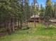 A serene creek flows near this log home, with an outdoor picnic area to enjoy nature at 8905 Carol Ln, Conifer, CO 80433